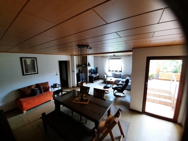 Großes Wohnzimmer mit Kamin, Flachbildfernseher und Zugang zum Wintergarten
