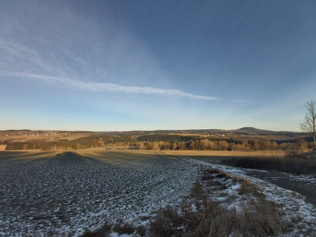 Das Foto zeigt den rheinland-pfälzischen Blick vom Ruppertsbergseifen-Forst, gelegen an der L 167, auf das nordrhein-westfälische Feriendorf Ahrdorf ,,Auf Busch''.  Im Hintergrund der ebenfalls in Rheinland-Pfalz gelegene, erhabene Aremberg mit seinen 560