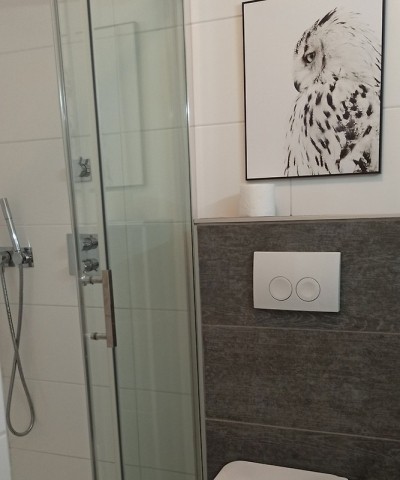 Badezimmer mit bodenebener Dusche, WC und Waschbecken