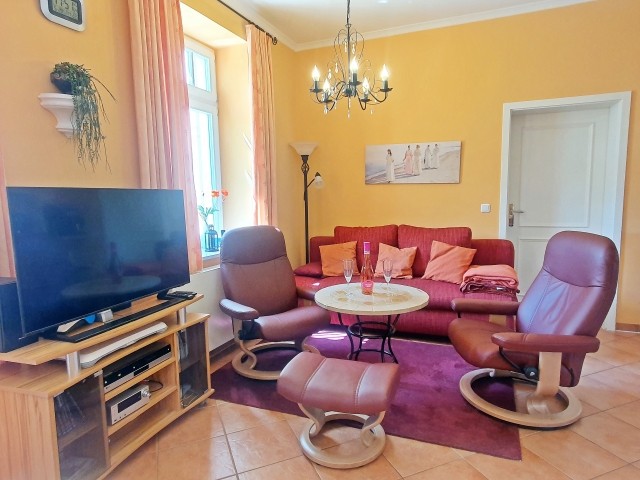 Gemütlicher Sitzbereich im Wohnzimmer (Stuck und Kronleuchter vermitteln Schlossatmoaphäre)