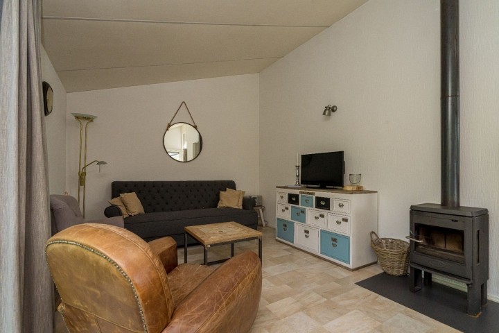 Das helle Wohnzimmer mit Sitzgruppe und Kaminofen