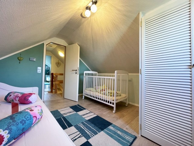 Schlafzimmer im Obergschoss mit Zugang zum Balkon