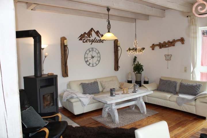 offenes, helles, liebevoll eingerichtetes Wohnzimmer mit Kamin