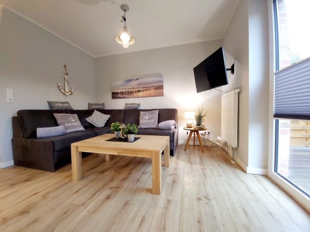 großzügiger Wohnbereich mit TV und Zugang zur Terrasse
