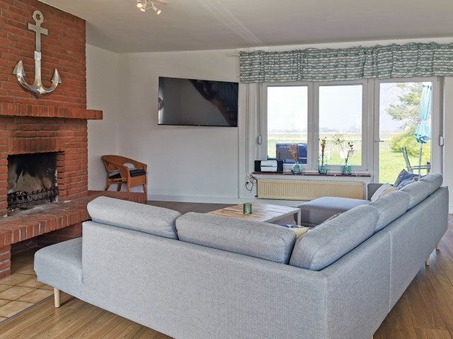 Wohnzimmer mit Fernseher und Kamin 