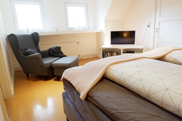 Schlafzimmer 1 mit Ohrensessel und TV