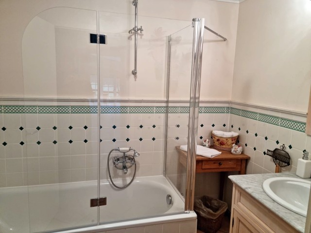 Bad mit Badewanne neben Schlafzimmer mit französischem Fenster im Erdgeschoß