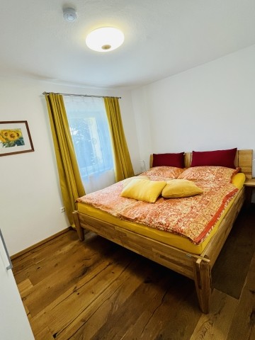 Schlafzimmer mit Eichenbett und gebürstetem, geöltem Eichenparkett