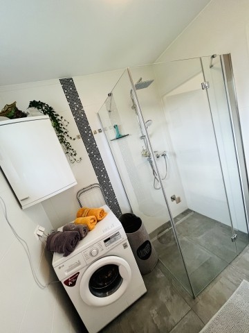 Badezimmer mit großer Dusche, Waschmaschine