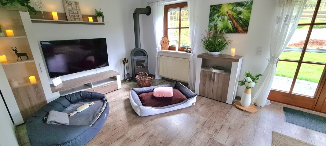 Wohnzimmer mit L-Lounge  Couch // 55 Zoll Smart TV // Kaminofen // große Terrassentür zum Garten // TOP WLAN