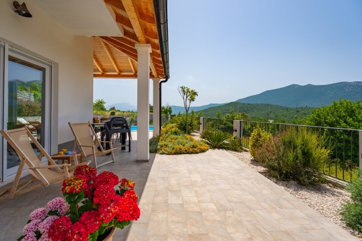 Der Sitzbereich im Freien befindet sich neben dem Pool und bietet einen atemberaubenden Blick auf die Berge.