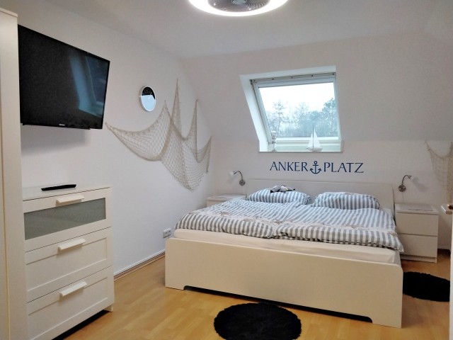 DG - Modernes Schlafzimmer mit TV im maritimen Look