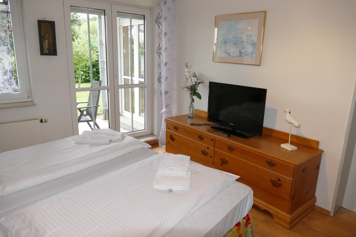 1. Schlafzimmer mit TV und Zugang zur Terrasse