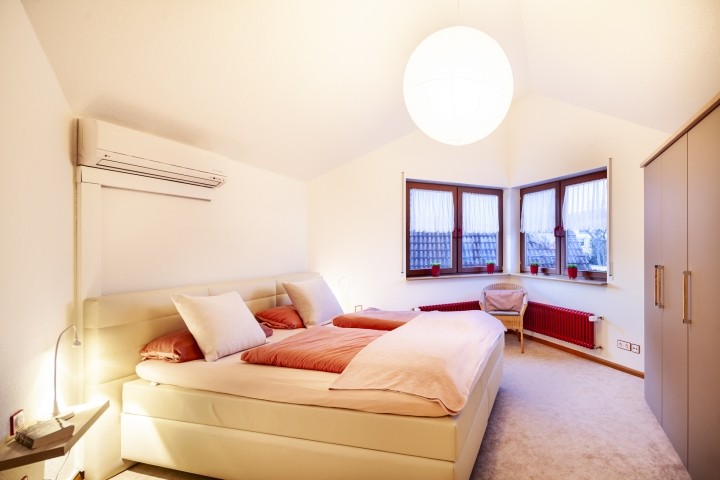 Schlafzimmer mit Boxspringbett und Blick auf den hinteren Garten