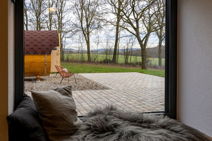 mit Blick in den Garten und auf die Fass-Sauna