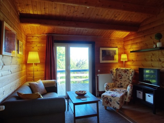 Wohnzimmer mit gemütlichem Sofa, Tisch und Ohrensessel