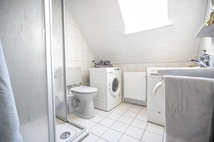 Helles Fenster-Duschbad mit Waschmaschine und Trockner