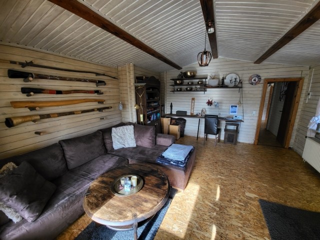 Oberes Wohnzimmer mit Schlafsofa und vielen Instrumenten (Klangschalen, Didgeridoos, Trommeln etc.)