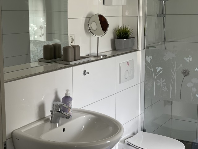 Das Bad ist modern mit bodengleicher Dusche