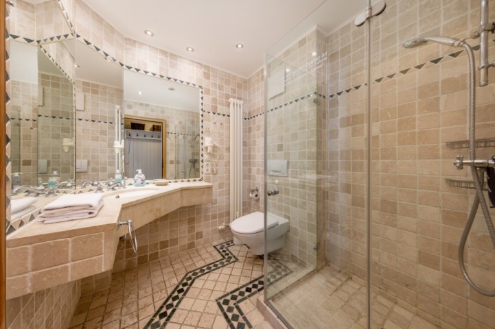 Das Natursteinbad mit Dusche, WC und Fön.
