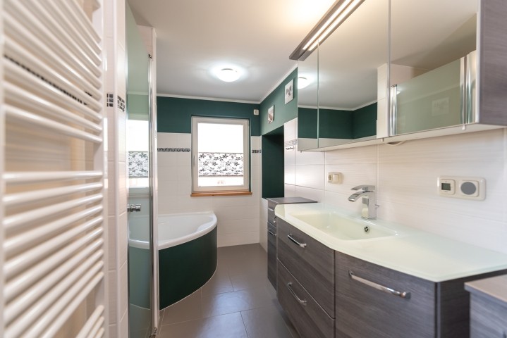 Badezimmer mit Badewanne, Dusche, WC und Waschmaschine