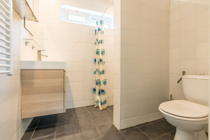 Badezimmer mit Dusche, Toilette und Waschbecken