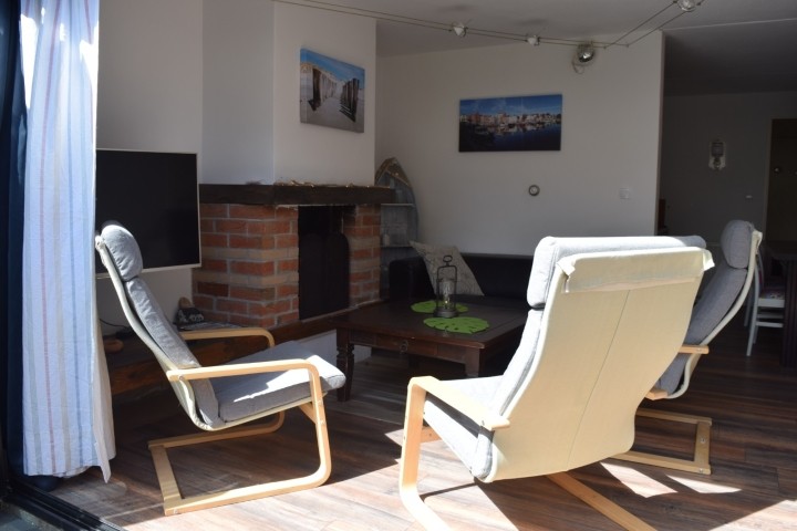 Blick von der Terrasse ins Wohnzimmer bei geöffneter Fensterfront