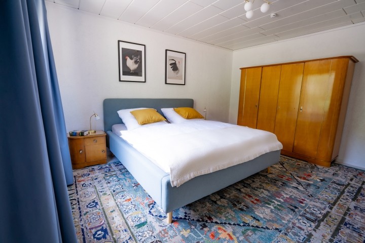Schlafzimmer mit Kung-Size Bett und aufgearbeiteten Vintage-Möbeln