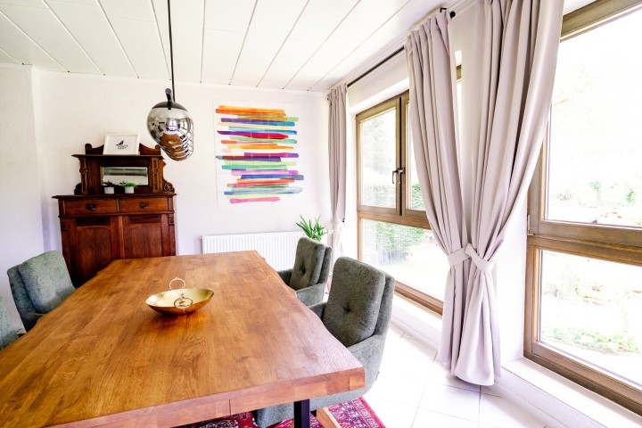 Wohn- und Essbereich mit heller Fensterfront, Kaminofen uns SMART-TV
