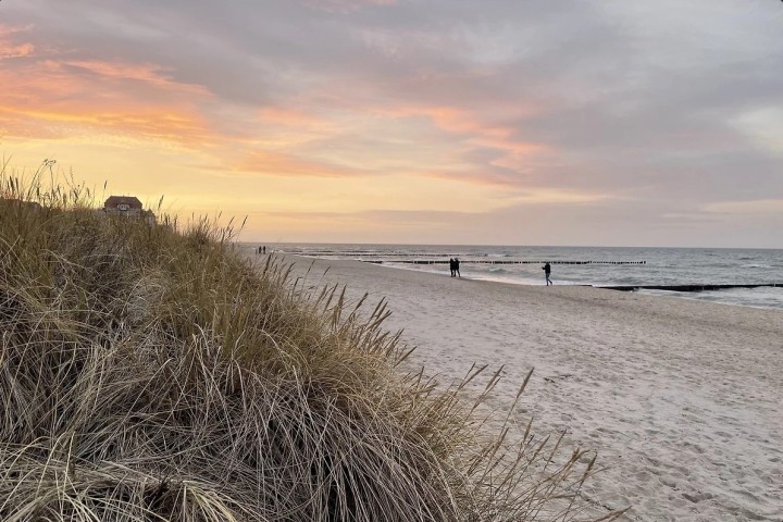 Faszinierende Küstenlandschaft mit ruhigem Wasser, goldenem Sand und atemberaubendem Sonnenuntergang