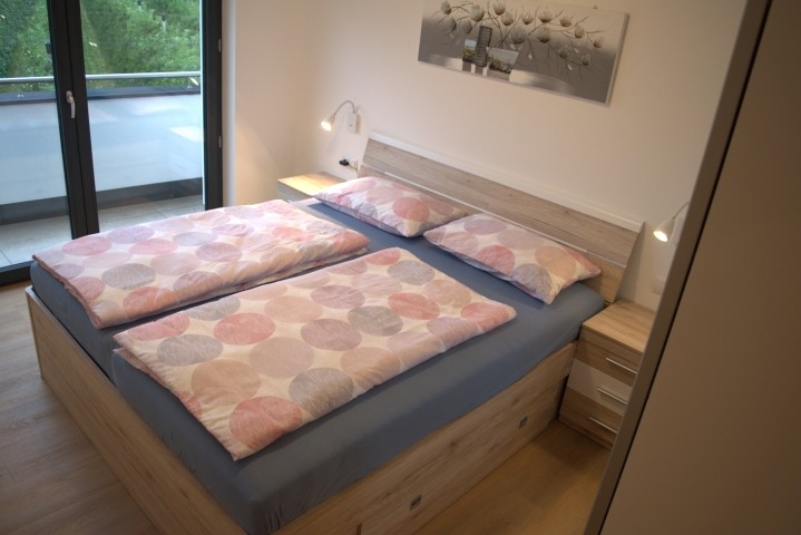 Schlafzimmer mit Doppelbett und Zugang zum Balkon
