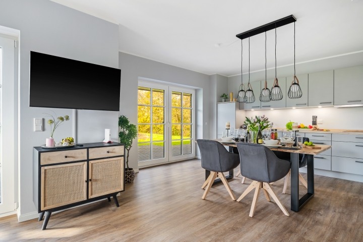 Blick in den Essbereich mit offener Küche und Zugang zur Terrasse