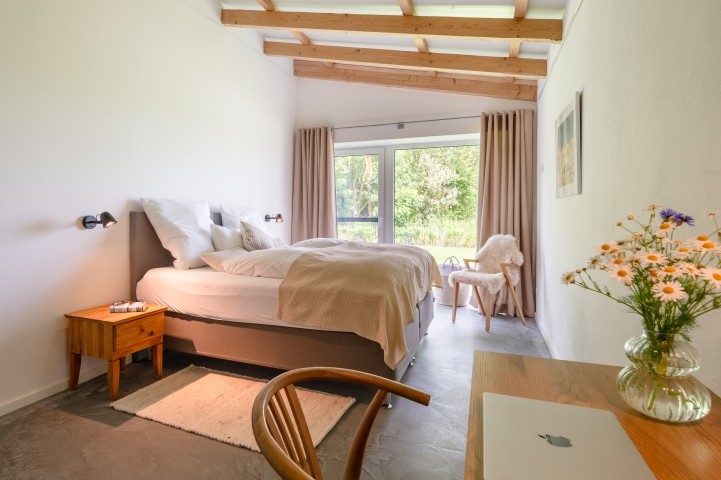 Großzügiges Schlafzimmer mit großem Doppelbett und Arbeitsplatz