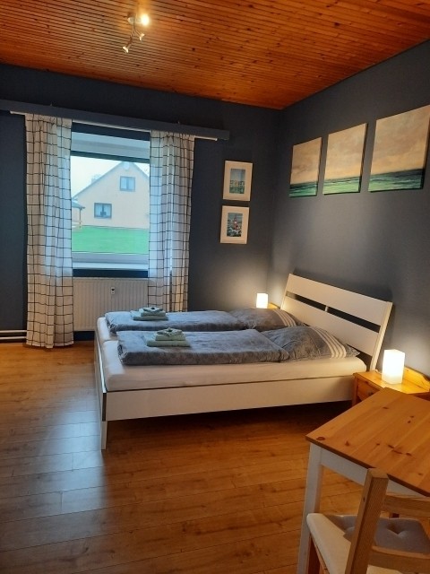 Zwei Schlafzimmer, eines mit Doppelbett und eines mit drei Einzelbetten 