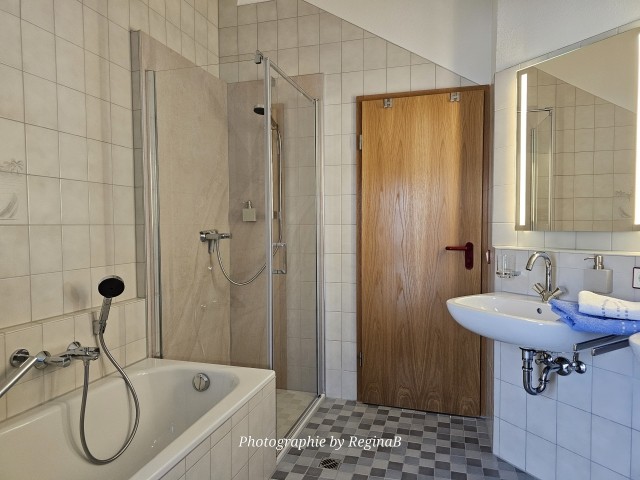 Badezimmer mit bodenebener Dusche/Wanne und WC