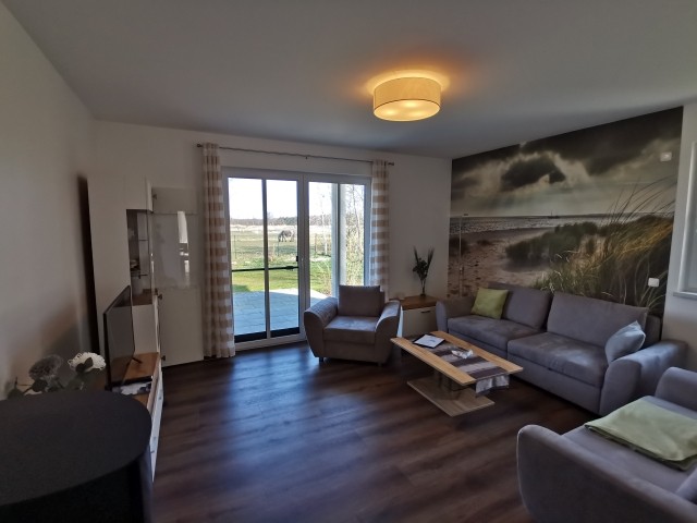 Wohnzimmer mit Zugang zur Terrasse und zum umzäunten Garten