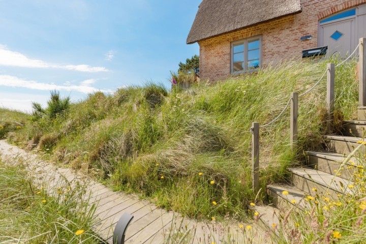 Steg zur Fasssauna und Terrasse mit Strandkorb und Meerblick