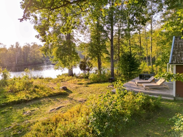 Blick über die Terrasse und den See an der ausgebauten Scheune