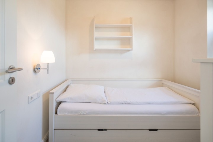Ferienhaus Basstölpel - Schlafzimmer im EG mit großem Einzelbett in 120x200 