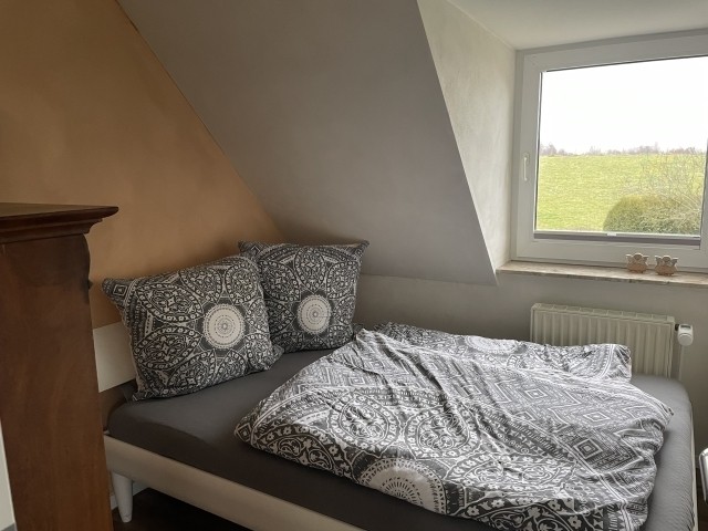 Kleines Schlafzimmer mit 1,40m Bett und Blick auf den Deich