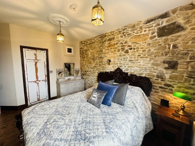 Hauptschlafzimmer mit Zugang zum Badezimmer und wunderschönem verzierten französischen Kingsize-Bett