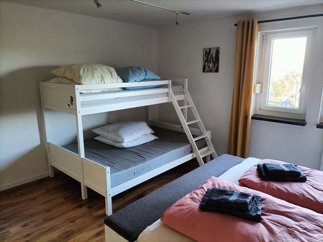 Schlafzimmer mit Doppelbett und Etagenbett