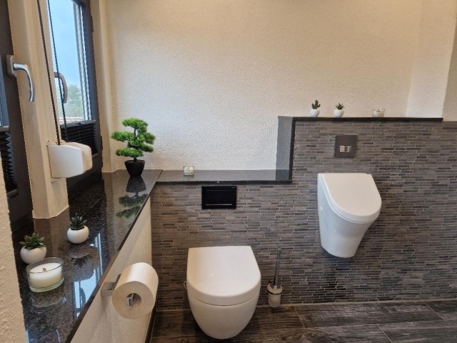 Badezimmer mit Toilette und Pissior