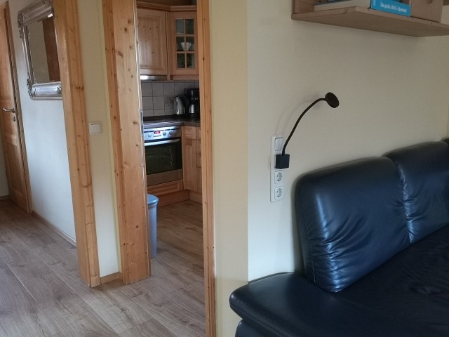 Blick im Wohnzimmer auf die Eingangstür und in die Küche