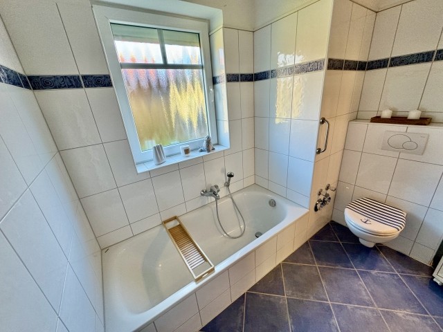 Badezimmer mit Badewanne und Dusche