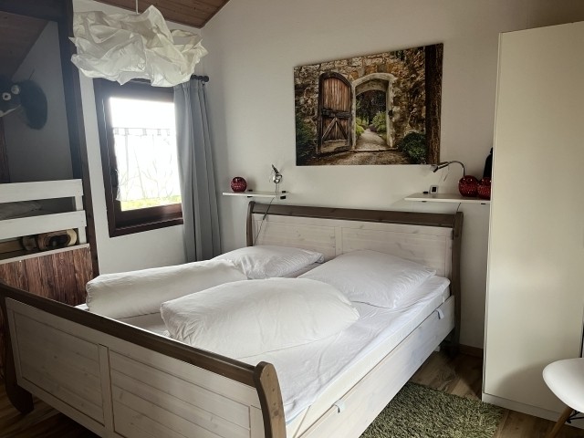 Schlafzimmer 2 mit Doppelbett, Schrank und Sessel