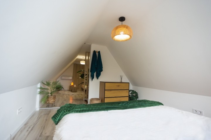 Ein helles, ruhiges Schlafzimmer mit sanften Tönen und natürlichen Akzenten. Kriechen Sie unter die Decke, atmen Sie tief durch und spüren Sie, wie die Stille Sie langsam in den Schlaf wiegt.
