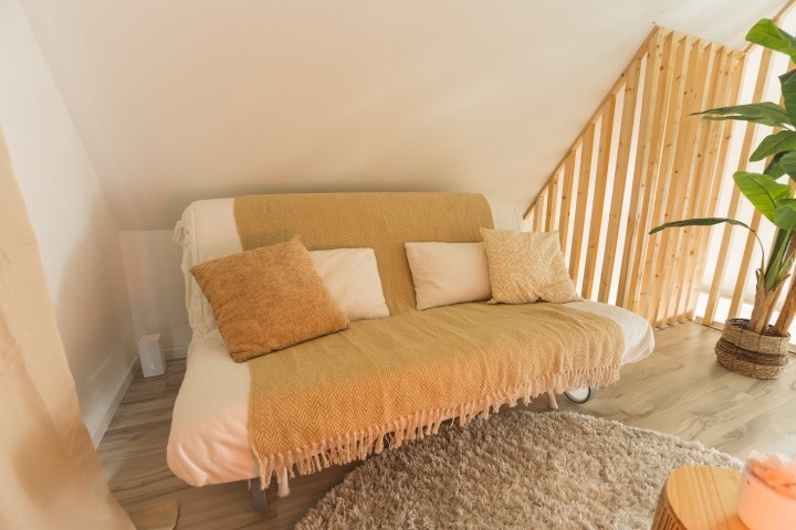 Deze zonnige hoek nodigt uit tot dagdromen, meditatie of een middagdutje. De bank verandert in een comfortabel tweepersoonsbed voor wie blijft slapen – of gewoon even niets wil.