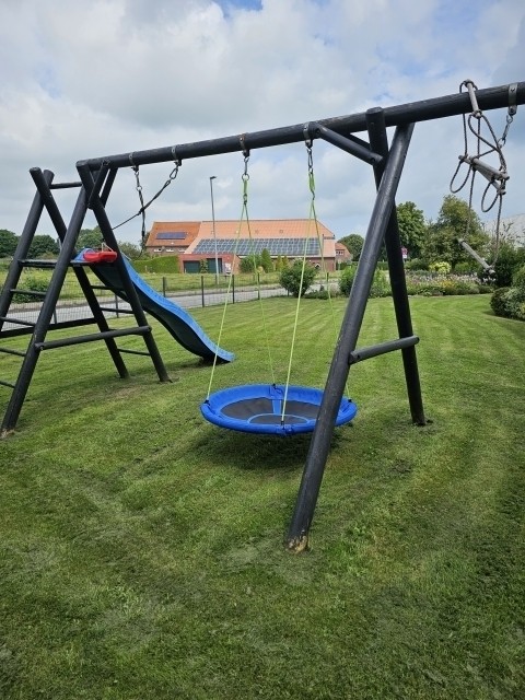Eingezäunter Garten mit Schaukel und Rutsche