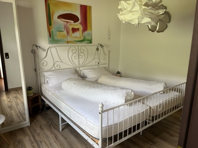 Schlafzimmer 1 mit Doppelbett, Schrank und Sessel